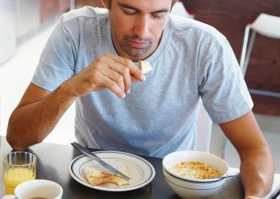 Mature man reading the newspaper while having breakfast