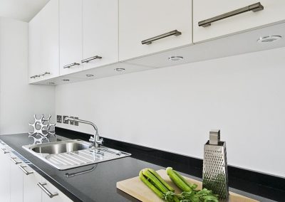 contemporary white kitchen with black granite worktop