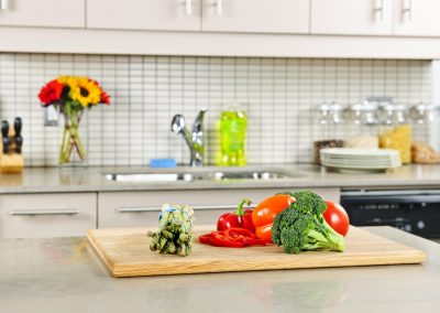 Modern kitchen interior with fresh vegetables on natural stone countertop