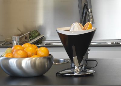 steel pans in modern kitchen and household appliances with orange and celery