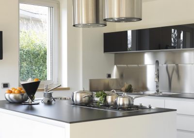 Modern kitchen with steel pans and vegetables on the steel top