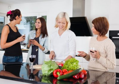 Group of happy female friends in kitchen